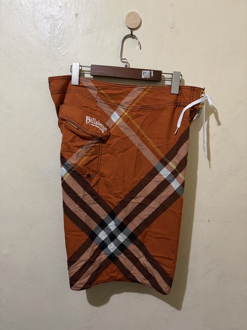 Billabong Board Shorts Orange Plaid Pattern (Category: Swim Trunks & Board Shorts) located in Bolinao. Submitted by ymondceleste (Listing ID 1460055555, Image 2). Description: - Orange board shorts with a classic plaid pattern. - Features the iconic Billabong logo embroidered on the pocket and back. - Comfortable drawstring waist for a secure fit. - Convenient back pocket with a button closure. - Ideal for swimming, surfing, or everyday casual we