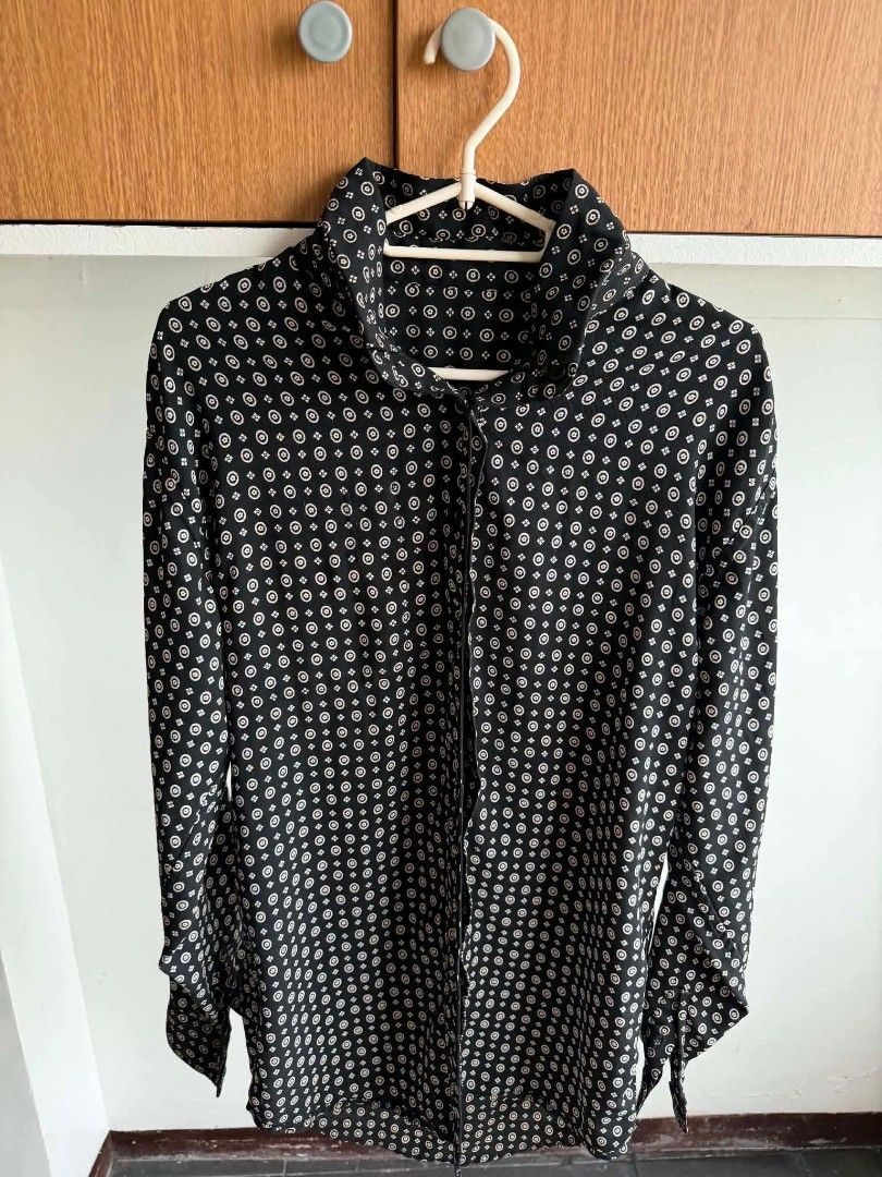 Black and white patterned long-sleeve blouse (Category: Blouses) located in Manila. Submitted by atozstuff (Listing ID 1460095243, Image 1). Description: - Elegant black long-sleeve blouse - Features a repeating white circular pattern - High neckline for a sophisticated look - Functional buttons down the front - Made from lightweight, flowy fabric - Perfect for dressing up or down - Easily pairs with trousers or skirts.