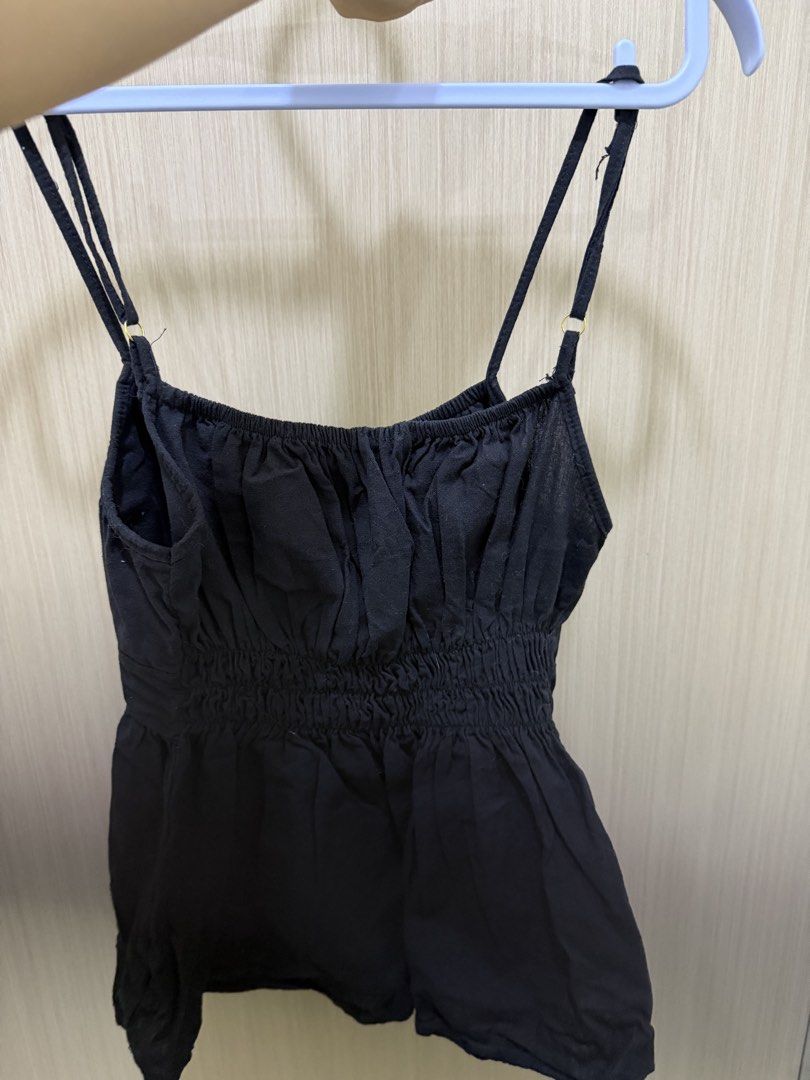 Black Cami Top with Buttons (Category: Sleeveless) located in Quezon City. Submitted by cozykath (Listing ID 1460009989, Image 2). Description: - Chic black cami top - Adjustable straps for a perfect fit - Flattering ruched bust detail - Stylish button-down front - Comfortable smocked back - Slightly flared hem for a feminine silhouette - Ideal for layering or wearing as a standalone piece.