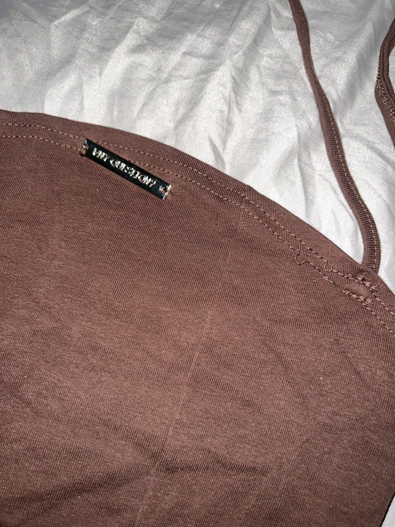 Brown Halter Tube top with silver hardware (Category: Others Tops) located in Paranaque City. Submitted by michcianox (Listing ID 1460019231, Image 2). Description: Silver hardware detail on the chest saying “any question?” With minor flaw on the stitch XS to S Price does not include shipping fee can ship through lalamove 📍meet up location: SM Sucat 💵 payment through gcash/maya.