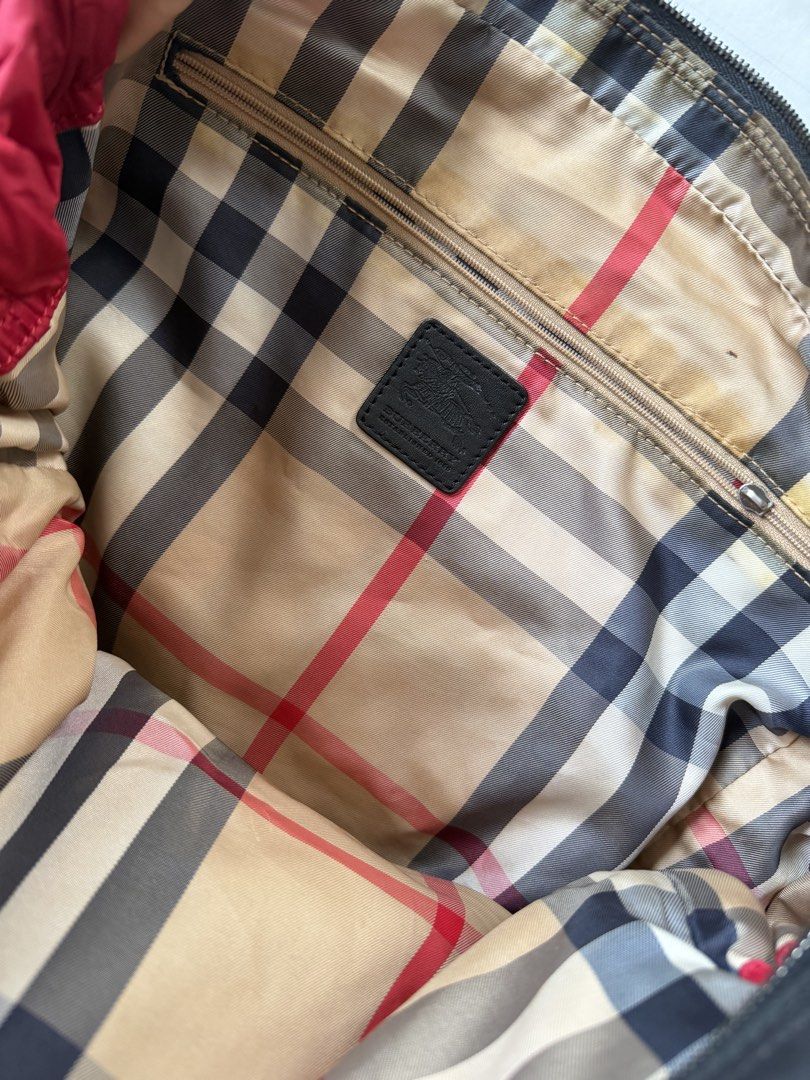 Burberry Nylon Tote Bag (Category: Tote Bags) located in Makati City. Submitted by curatedandnearlynew (Listing ID 1460026225, Image 3). Description: Burberry Nylon Tote Bag - Adjustable nylon tote bag with leather drawstrings - Red exterior with classic Burberry check print interior - Very roomy and can fit a laptop. Perfect work bag! - With stain on the side .