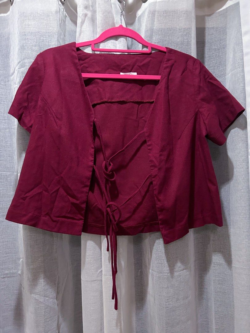 Burgundy Cropped Tie Blouse (Category: Blouses) located in Cainta. Submitted by unboxingstuff (Listing ID 1460048275, Image 1). Description: - Burgundy cropped top with ties - Short sleeves - Textured fabric; linen mix - Measurements: Approx. 15" chest, 17" length - Ideal for layering over tops or dresses.