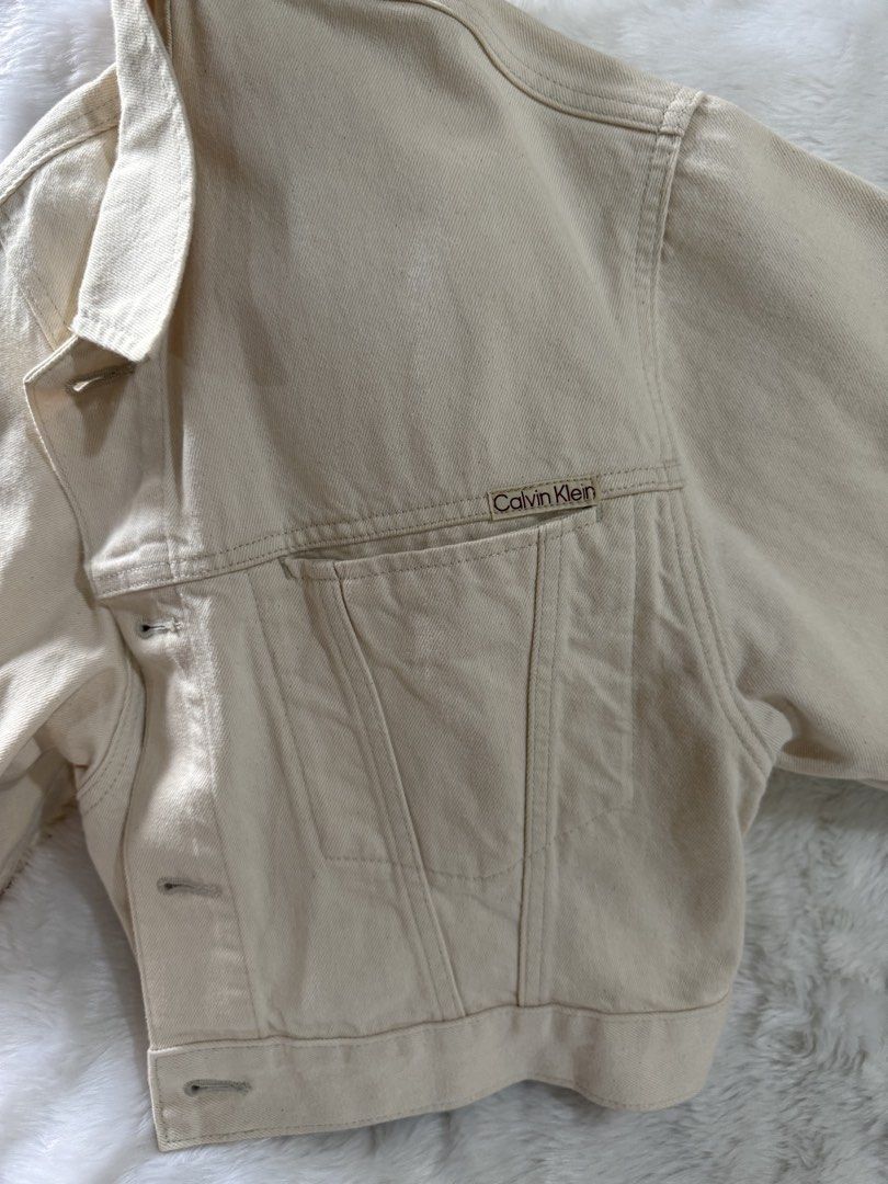 Calvin Klein Beige Cropped Denim Jacket (Category: Coats, Jackets and Outerwear) located in Quezon City. Submitted by jezjewels.ph (Listing ID 1459972827, Image 2). Description: - Brand new beige Calvin Klein denim jacket - Cropped style - Button closures - Chest pockets with Calvin Klein logo - Still has original tags attached - Perfect staple piece for any outfit Kept unused Wrong size US bought.