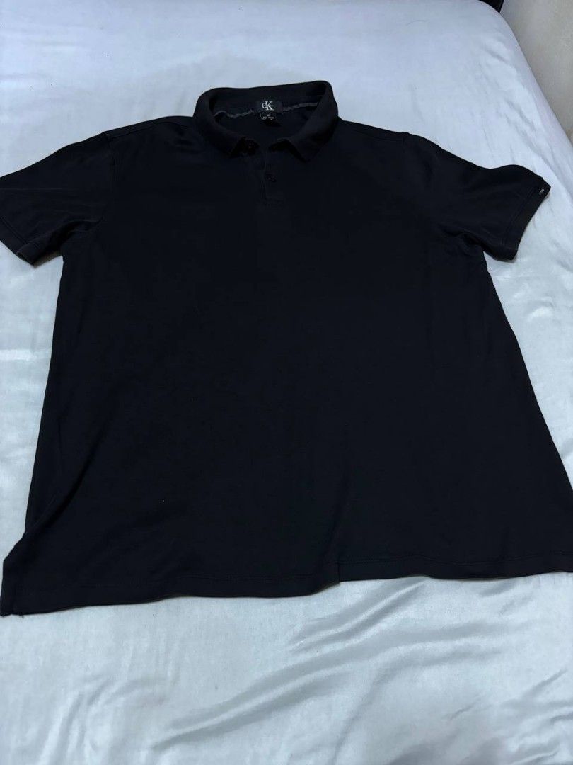 Calvin Klein Black Polo Shirt (Category: Tshirts & Polo Shirts ) located in Pasig City. Submitted by heneralsupremo1892 (Listing ID 1460097670, Image 1). Description: - Classic black Calvin Klein polo shirt - Short sleeves for comfort - Features CK logo on the collar - Small Calvin Klein tag on the side hem - Versatile for casual or smart-casual looks - Easily pairs with jeans or shorts - Authentic and Legit❗ - Very Good Condition/ Almost New 🔥 