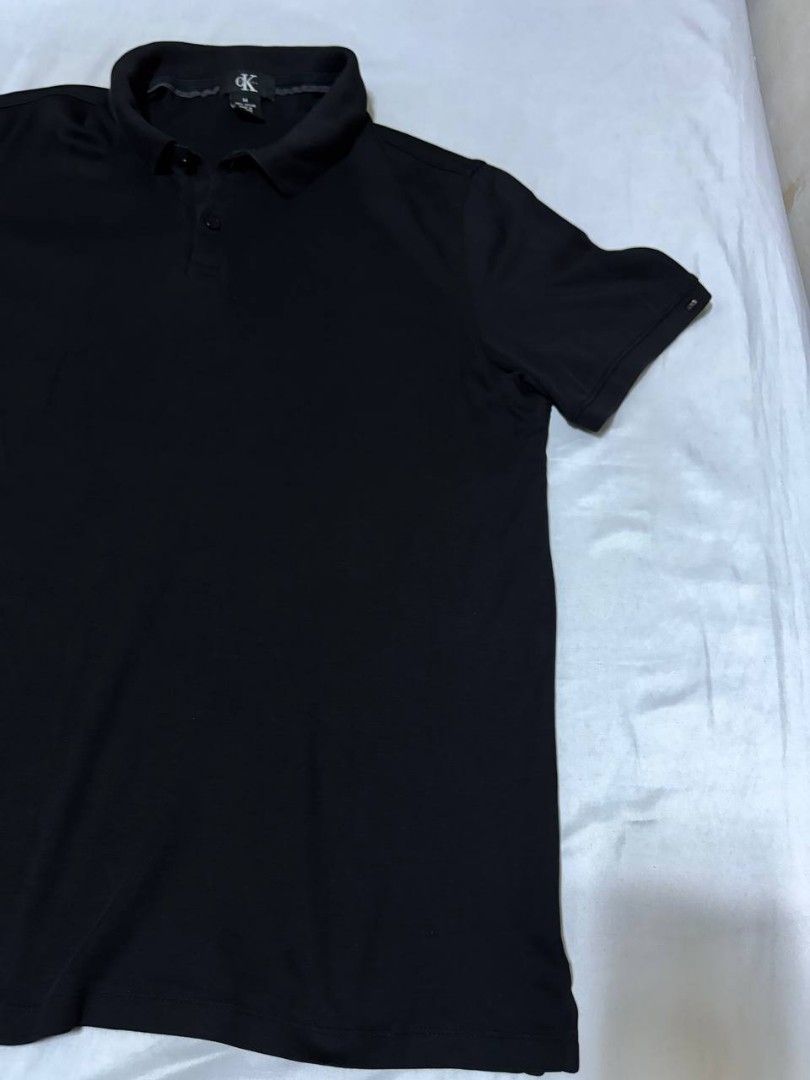 Calvin Klein Black Polo Shirt (Category: Tshirts & Polo Shirts ) located in Pasig City. Submitted by heneralsupremo1892 (Listing ID 1460097670, Image 3). Description: - Classic black Calvin Klein polo shirt - Short sleeves for comfort - Features CK logo on the collar - Small Calvin Klein tag on the side hem - Versatile for casual or smart-casual looks - Easily pairs with jeans or shorts - Authentic and Legit❗ - Very Good Condition/ Almost New 🔥 