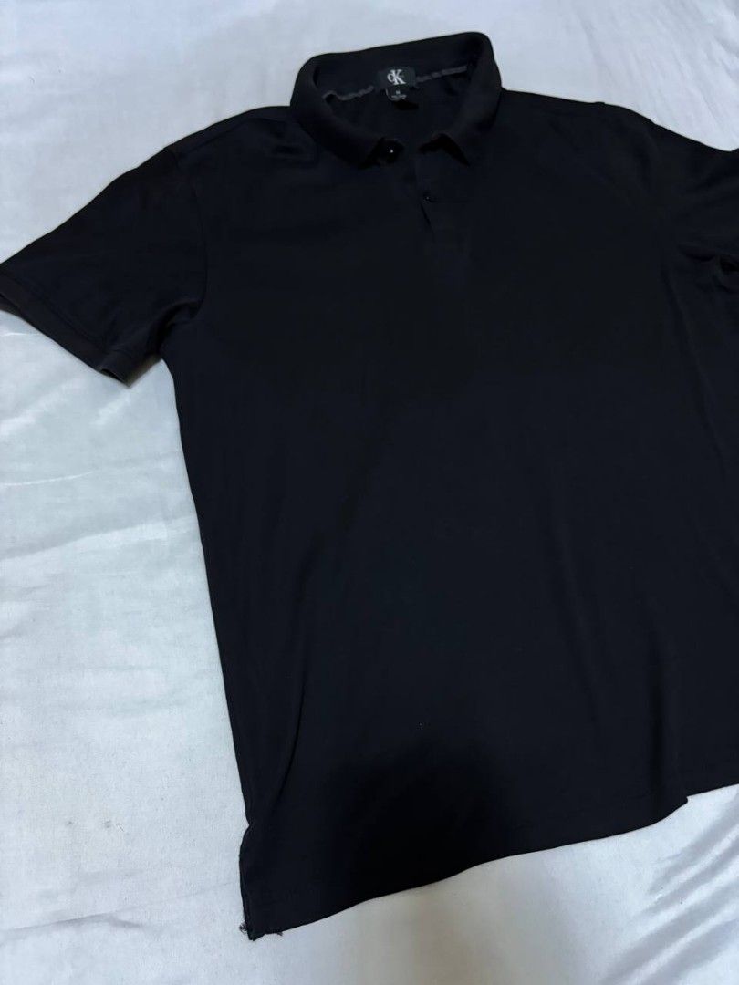 Calvin Klein Black Polo Shirt (Category: Tshirts & Polo Shirts ) located in Pasig City. Submitted by heneralsupremo1892 (Listing ID 1460097670, Image 2). Description: - Classic black Calvin Klein polo shirt - Short sleeves for comfort - Features CK logo on the collar - Small Calvin Klein tag on the side hem - Versatile for casual or smart-casual looks - Easily pairs with jeans or shorts - Authentic and Legit❗ - Very Good Condition/ Almost New 🔥 