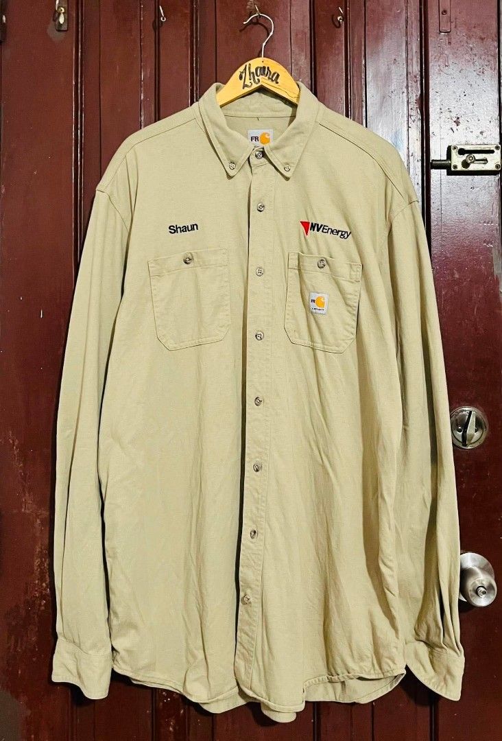 CARHARTT FR WORK SHIRT (Category: Coats, Jackets and Outerwear) located in Pagsanjan. Submitted by thriftyclothes33 (Listing ID 1460062385, Image 2). Description: CARHARTT FR WORK SHIRT 🟤🔥 💰 ₱750 + SF 🛠️ Flame-Resistant (FR) work shirt ⚡ Utility / workwear style 🏷️ NV Energy employee customization 🪡 Carhartt logo patch 🧥 Button-front design 🎨 Classic khaki color 🏷️ XL on tag — best fit 2XL 📏 Width 27" • Length 33" 👍🏻 VeryGood conditio