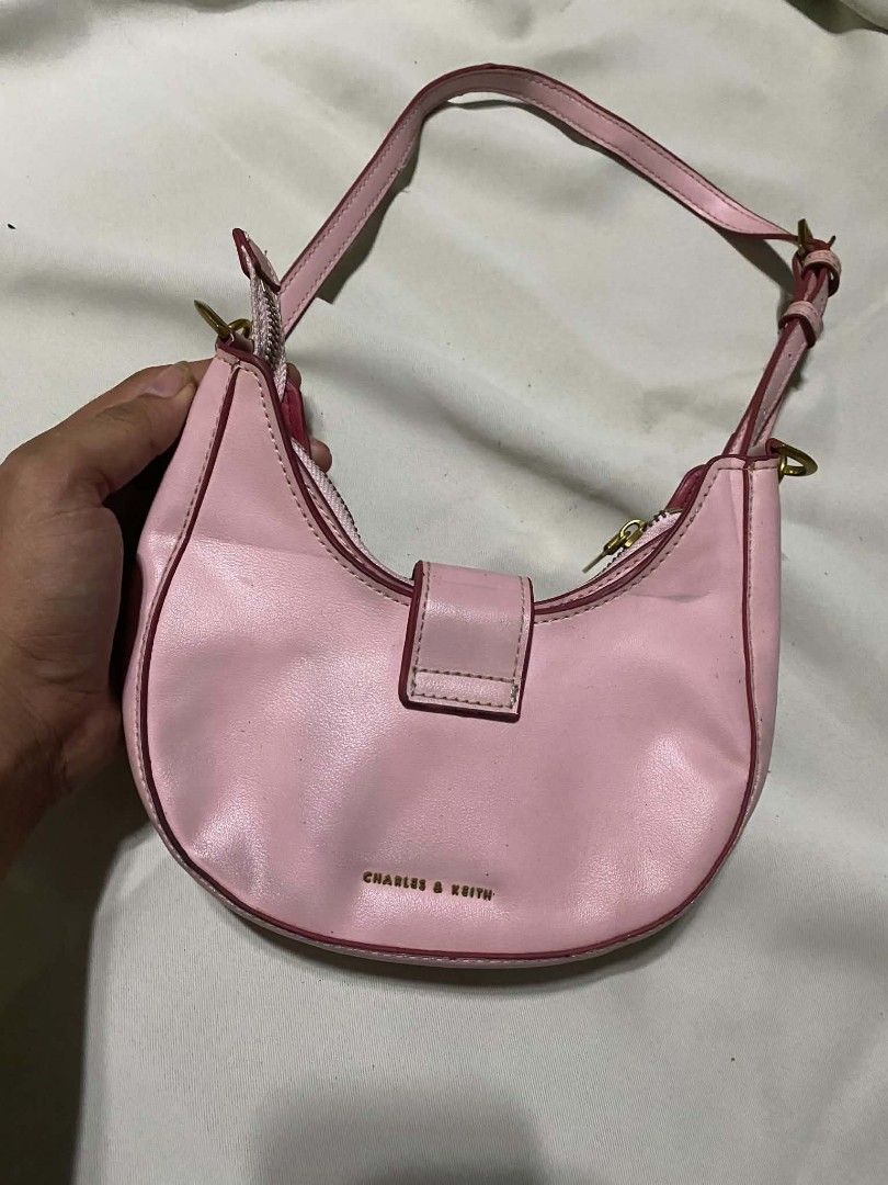 Charles & Keith Pink Shoulder Bag with ITZY Charm (Category: Shoulder Bags) located in Taguig. Submitted by althriftdailyloots94 (Listing ID 1460040324, Image 1). Description: - Cute pink shoulder bag from Charles & Keith - Features a small strap and secure buckle closure - Bright pink interior - Adorable 'ITZY' charm attached - Perfect for carrying your essentials - Zippers are in good working condition - Minor signs of wear on edges, overall st