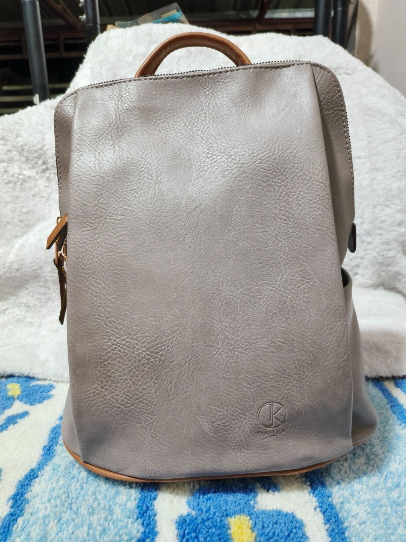 D Kelly Grey Faux Leather Backpack (Category: Backpacks) located in San Leonardo. Submitted by burgossanleonardo.12345 (Listing ID 1460066981, Image 1). Description: - Grey D Kelly backpack - Faux leather material - Top handle and adjustable straps - Subtle front logo detail - Spacious interior - Ideal for everyday use or travel.