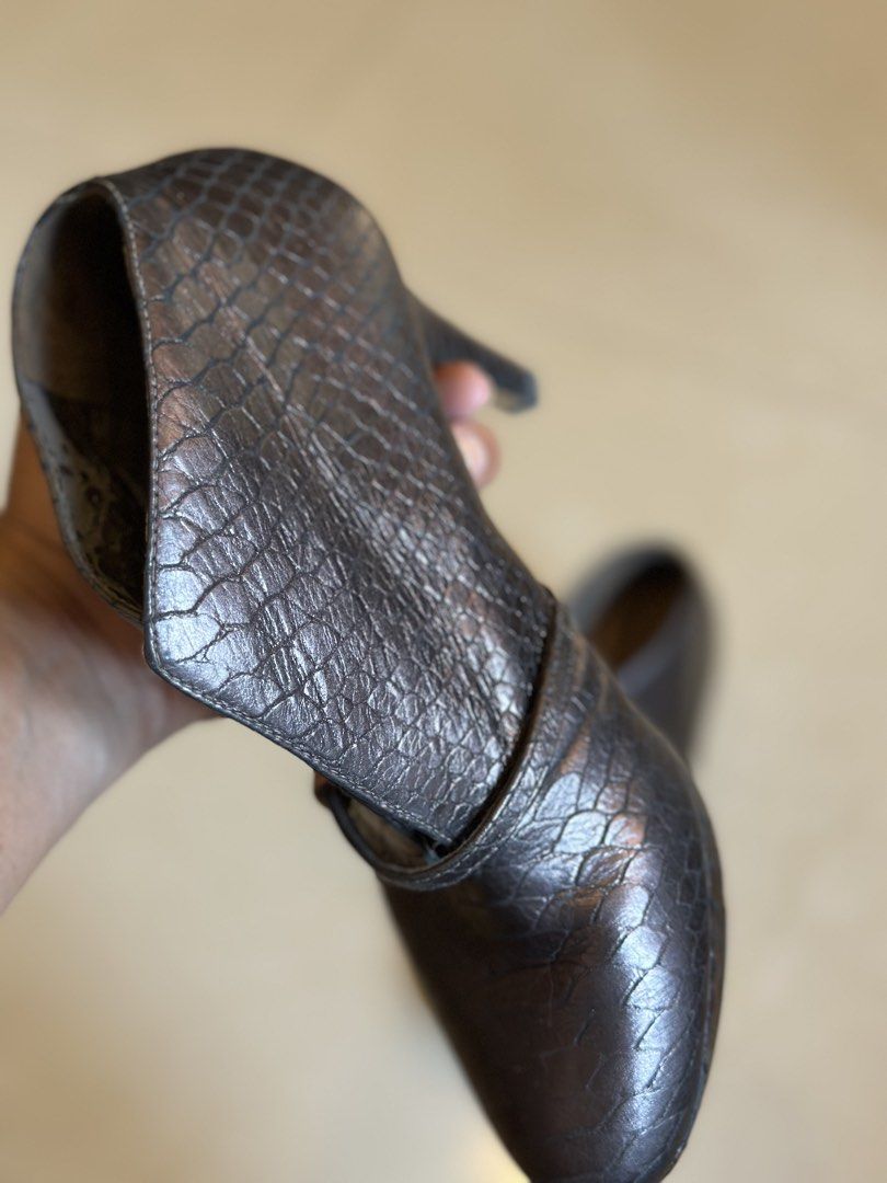 Clarks Metallic Snake Print Heeled Ankle Boots (Category: Boots) located in Manila. Submitted by timelessfindsbyjoann (Listing ID 1460073380, Image 3). Description: Metallic ankle boots with a snake print texture. Features a pointed toe and a stiletto heel. There's a small strap detail across the front. The inside shows the Clarks logo. These have a unique cut-out design on the sides. Great for dressing up an outfit..