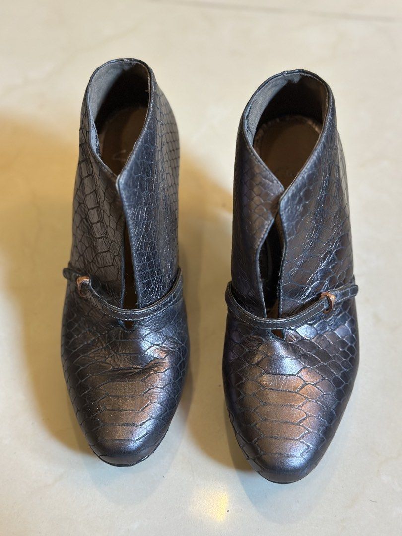 Clarks Metallic Snake Print Heeled Ankle Boots (Category: Boots) located in Manila. Submitted by timelessfindsbyjoann (Listing ID 1460073380, Image 2). Description: Metallic ankle boots with a snake print texture. Features a pointed toe and a stiletto heel. There's a small strap detail across the front. The inside shows the Clarks logo. These have a unique cut-out design on the sides. Great for dressing up an outfit..