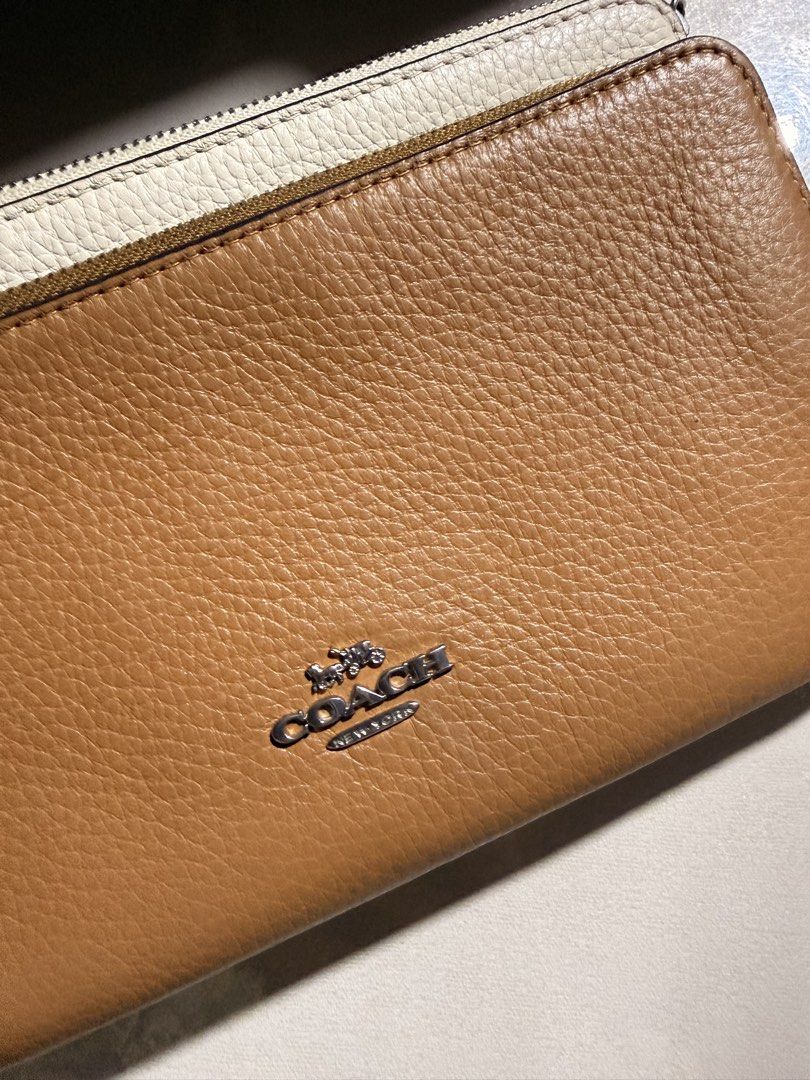 Coach Brown and White Leather Double Zip Wristlet (Category: Wallets & Card holders) located in San Fernando. Submitted by marynicole2911 (Listing ID 1459977248, Image 2). Description: - Authentic Coach wristlet in brown and off-white leather. - Features two zip compartments. - Includes a convenient wrist strap. - Plenty of card slots inside for organization. - Clean interior. - Zipper pulls showcase the Coach New York logo - Good as new, no issu
