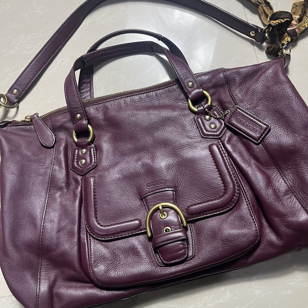 Coach Leather Handbag with Scarf (Category: Luxury Bags & Wallets) located in Manila. Submitted by direcmampu37948 (Listing ID 1459918102, Image 2). Description: - Deep purple genuine leather Coach handbag - Elegant gold hardware - Convenient front buckle pocket - Secure top zip closure - Interior zip pocket for essentials - Comes with a stylish decorative scarf tied to the strap - Please note: Minor marks on leather, as shown in the provided pho