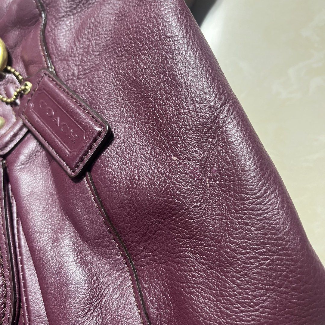 Coach Leather Handbag with Scarf (Category: Luxury Bags & Wallets) located in Manila. Submitted by direcmampu37948 (Listing ID 1459918102, Image 3). Description: - Deep purple genuine leather Coach handbag - Elegant gold hardware - Convenient front buckle pocket - Secure top zip closure - Interior zip pocket for essentials - Comes with a stylish decorative scarf tied to the strap - Please note: Minor marks on leather, as shown in the provided pho
