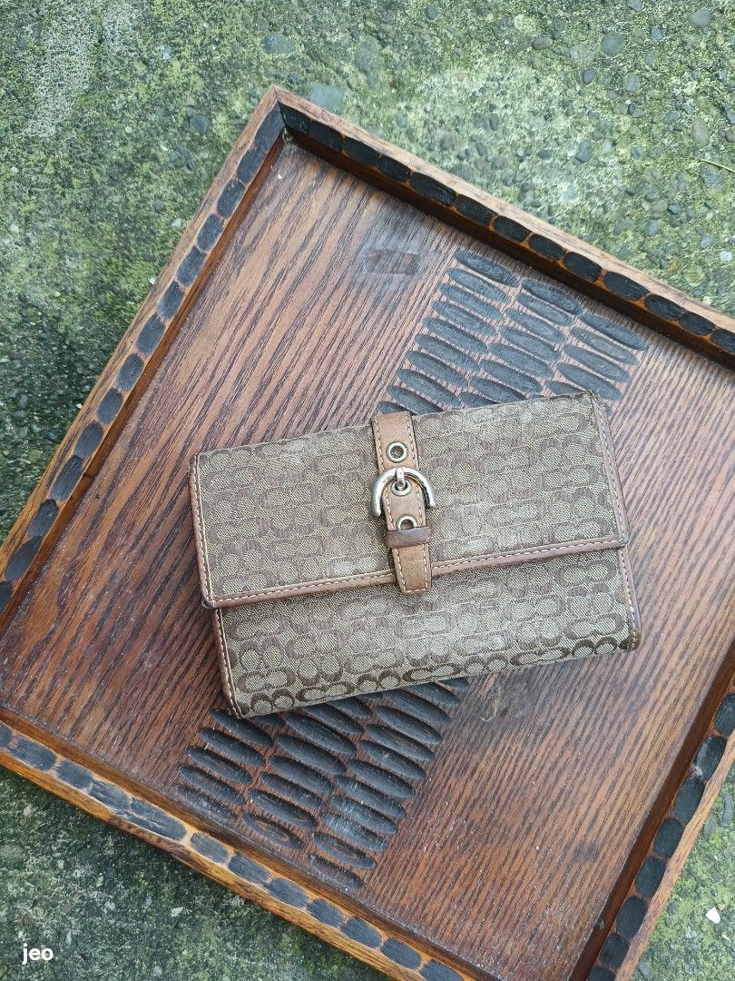 Coach Monogram Canvas Bifold Wallet with Buckle (Category: Luxury Bags & Wallets) located in Pavia. Submitted by deusk (Listing ID 1460051064, Image 1). Description: - Authentic Coach wallet - Classic monogram canvas with leather trim - Secure buckle closure - Bifold design with multiple card slots and compartments - needs cleaning and conditioning - Perfect for everyday use.
