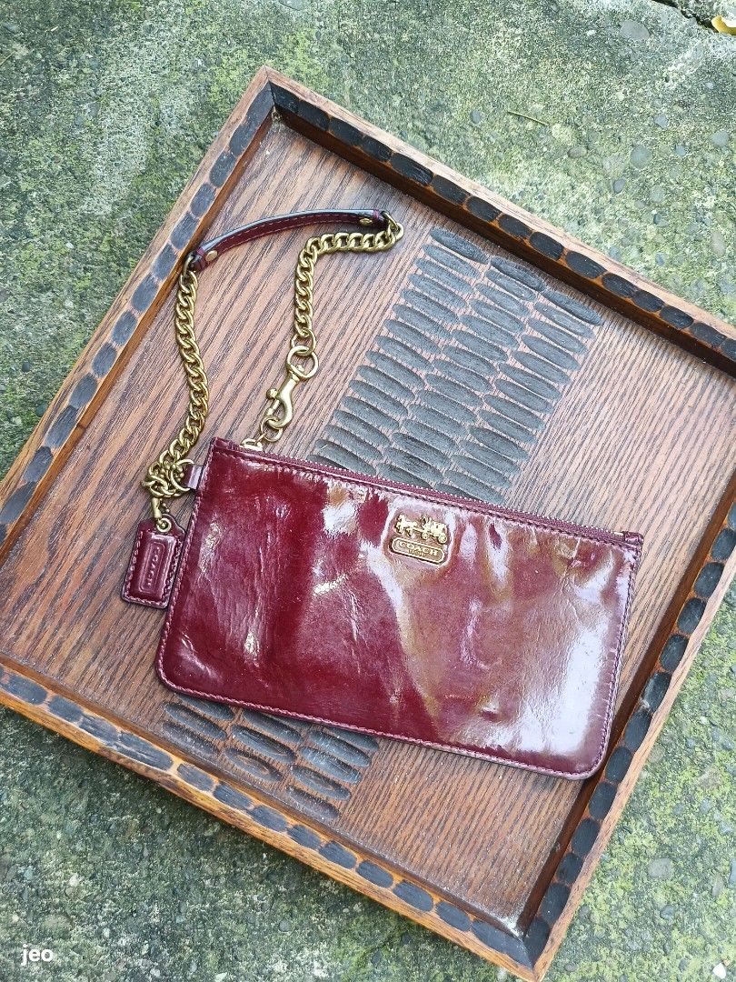 Coach Patent Leather chain wristlet (Category: Purses & Pouches) located in Pavia. Submitted by deusk (Listing ID 1460048136, Image 1). Description: - Shiny burgundy patent leather Coach wristlet - Gold chain strap and small wristlet strap included - Interior features card slots for essentials - Smooth and reliable zipper closure - A classic and versatile Coach accessory.