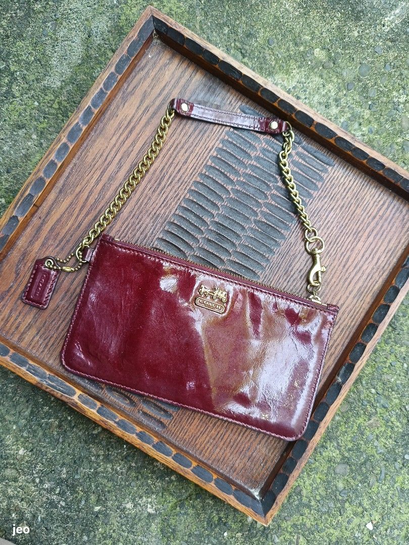 Coach Patent Leather chain wristlet (Category: Purses & Pouches) located in Pavia. Submitted by deusk (Listing ID 1460048136, Image 3). Description: - Shiny burgundy patent leather Coach wristlet - Gold chain strap and small wristlet strap included - Interior features card slots for essentials - Smooth and reliable zipper closure - A classic and versatile Coach accessory.