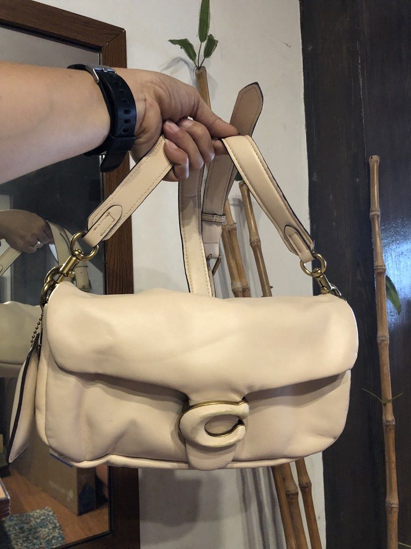 Coach Pillow Tabby Shoulder Bag 18 Cream (Category: Luxury Bags & Wallets) located in Quezon City. Submitted by yunajohan24 (Listing ID 1459968706, Image 1). Description: - Cream colored Coach Pillow Tabby bag - Made with soft, puffy leather - Features iconic C hardware closure - Comes with both a chain strap and a shoulder strap - Versatile for everyday use or evening outings.
