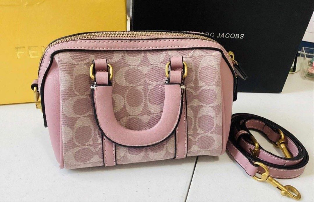Coach Pink Monogram Mini Barrel Bag (Category: Luxury Bags & Wallets) located in Batangas. Submitted by melocollects (Listing ID 1459977297, Image 1). Description: - Cute pink Coach mini barrel bag - Classic Coach monogram pattern - Top handles - Detachable crossbody strap - Gold hardware details - Soft lavender interior - Ideal for carrying essentials.