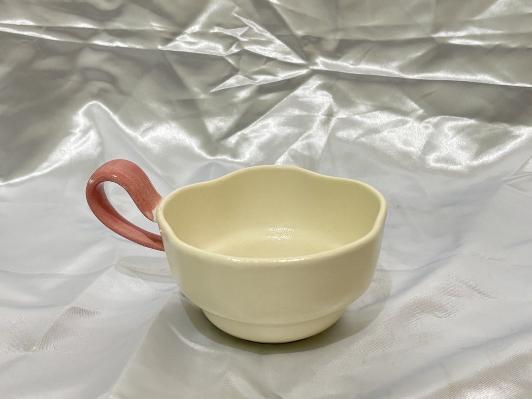 Cream Ceramic Mug with Pink Handle (Category: Coffee & Tea Tableware) located in San Pedro. Submitted by meirene19 (Listing ID 1460027235, Image 2). Description: - Adorable cream-colored mug - Unique wavy rim design - Sweet soft pink handle - Ideal for your morning coffee or tea - Dishwasher safe for easy cleaning - Holds a generous amount of your favorite beverage.