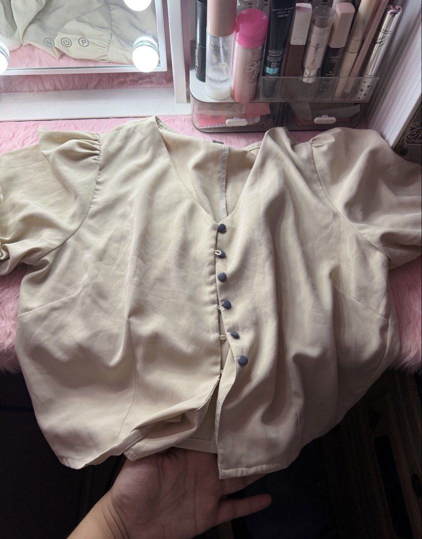 Cream Puff Sleeve Button-Up Blouse (Category: Blouses) located in San Fernando. Submitted by iammaryjoy58877 (Listing ID 1459950418, Image 1). Description: - Cream colored blouse - Puff sleeves - V-neckline - Button-up front with dark grey buttons - Silky/satin-like material - Versatile for dressing up or down - Comfortable fit.
