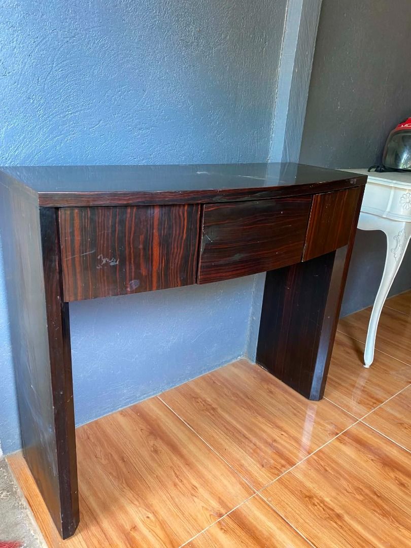 Dark Wood Console Table with 3 Drawers (Category: Tables & Sets) located in Minglanilla. Submitted by naquilagretchen (Listing ID 1460038607, Image 2). Description: - Stylish dark wood console table - Unique curved front design - Three smooth-gliding drawers for storage - Beautiful natural wood grain pattern - Minor scratches on the top surface, adding character - Ideal for entryways, hallways, or as a chic side table - Dimensions: Approximately 