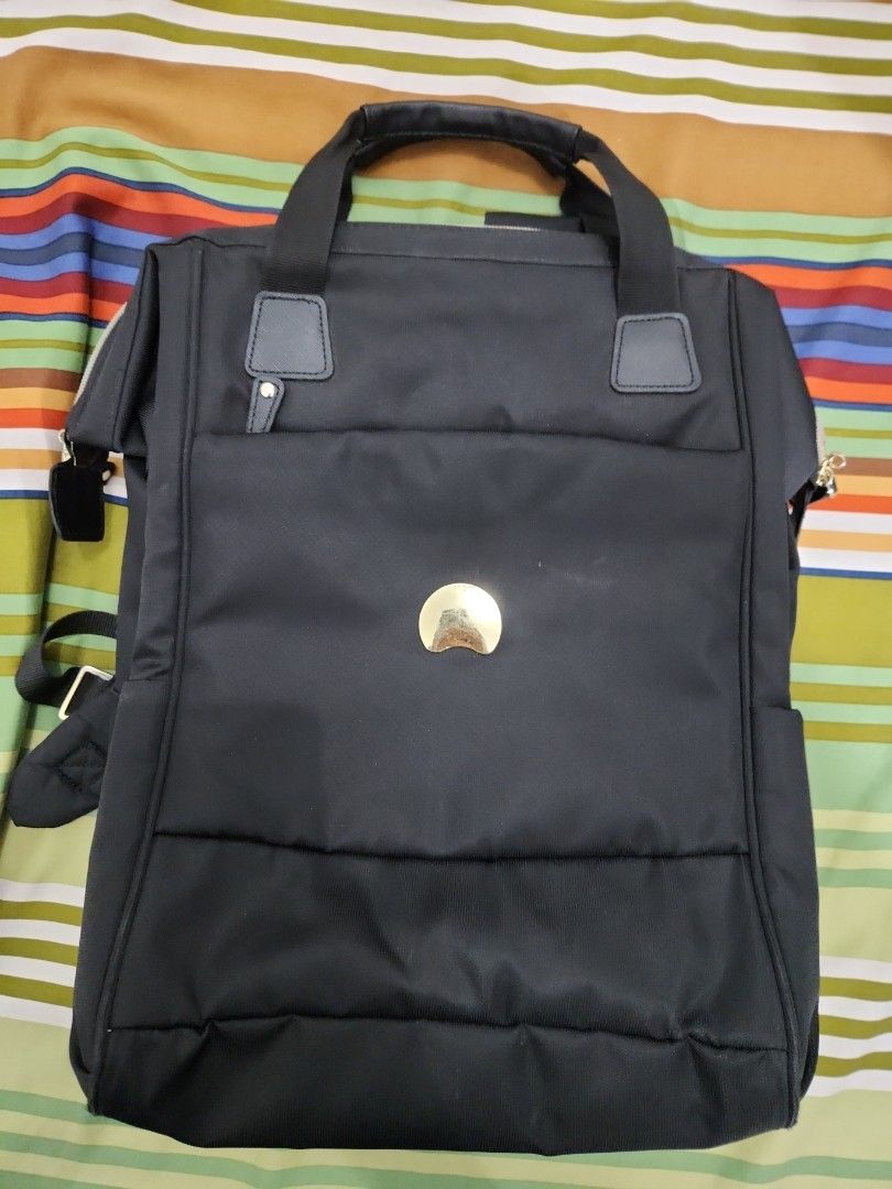 DELSEY Paris Black Backpack with Gold Accent (Category: Backpacks) located in Manila. Submitted by happybear_77e59e777 (Listing ID 1460029380, Image 1). Description: - Brand: DELSEY Paris - Color: Black - Accent: Gold detail on the front - Interior: Unique patterned lining - Features: Multiple compartments for organization - Ideal for: Daily use or travel - This is good for men or women - In good condition.