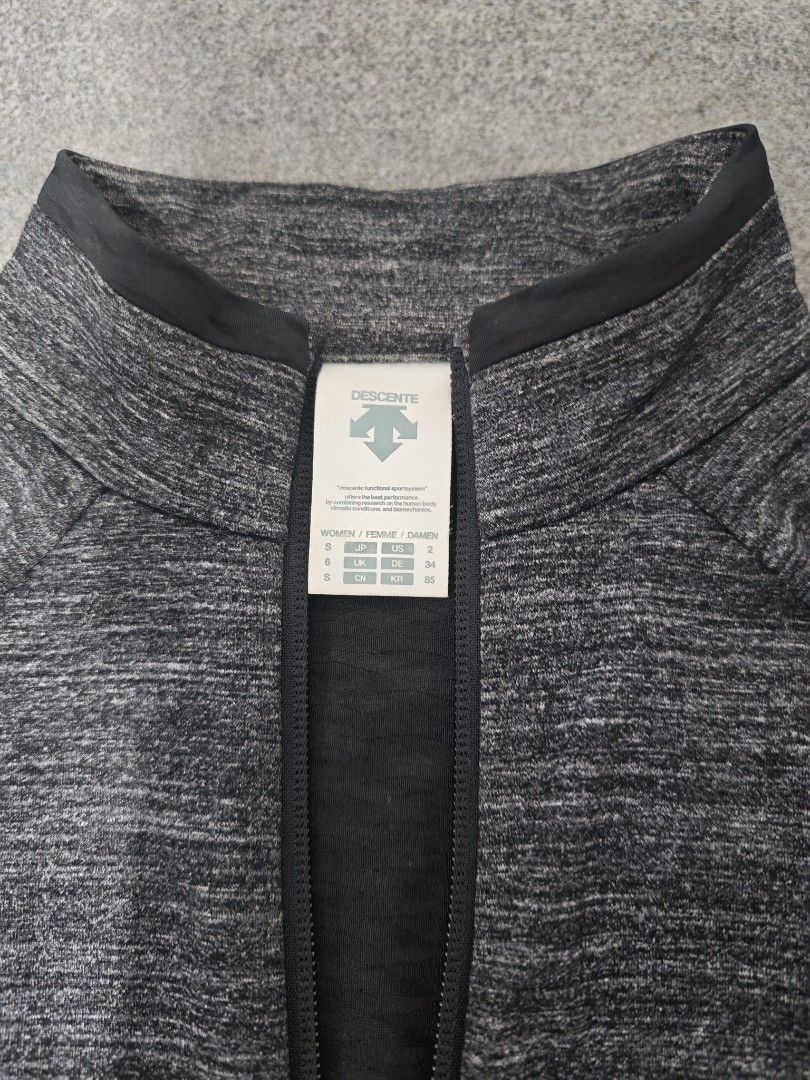 Descente Women's Grey Heathered Full Zip Jacket (Category: Coats, Jackets and Outerwear) located in Baguio. Submitted by goku_doggo (Listing ID 1460012491, Image 2). Description: - Descente Women's Jacket - Color: Grey heathered with black lower panel - Style: Full zip front with stand-up collar - Features: Two zippered side pockets - Ideal for: Workouts or casual wear - Size: S.