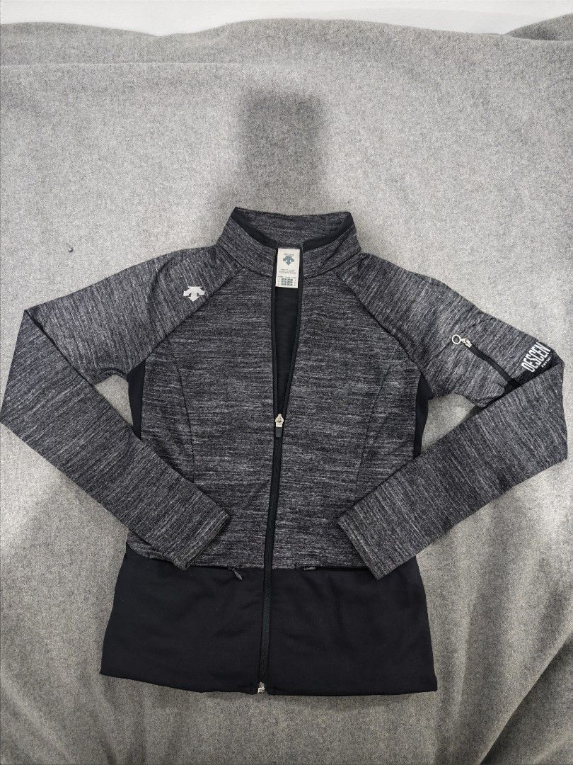 Descente Women's Grey Heathered Full Zip Jacket (Category: Coats, Jackets and Outerwear) located in Baguio. Submitted by goku_doggo (Listing ID 1460012491, Image 1). Description: - Descente Women's Jacket - Color: Grey heathered with black lower panel - Style: Full zip front with stand-up collar - Features: Two zippered side pockets - Ideal for: Workouts or casual wear - Size: S.