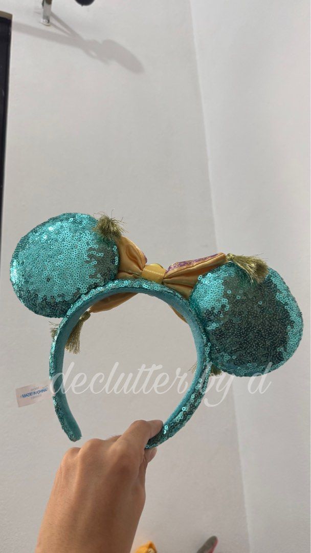 Disney Magic Carpet aladdin Ears jasmine Headband (Category: Handmade Craft) located in Muntinlupa City. Submitted by declutter.by.d (Listing ID 1459994704, Image 2). Description: - Eye-catching turquoise sequin Minnie Mouse ears. - Unique bow designed like Aladdin's magic carpet. - Features decorative tassels on the sides of the bow. - Adorned with a sparkling blue gem in the center of the bow. - A must-have accessory for any Disney enthusiast o