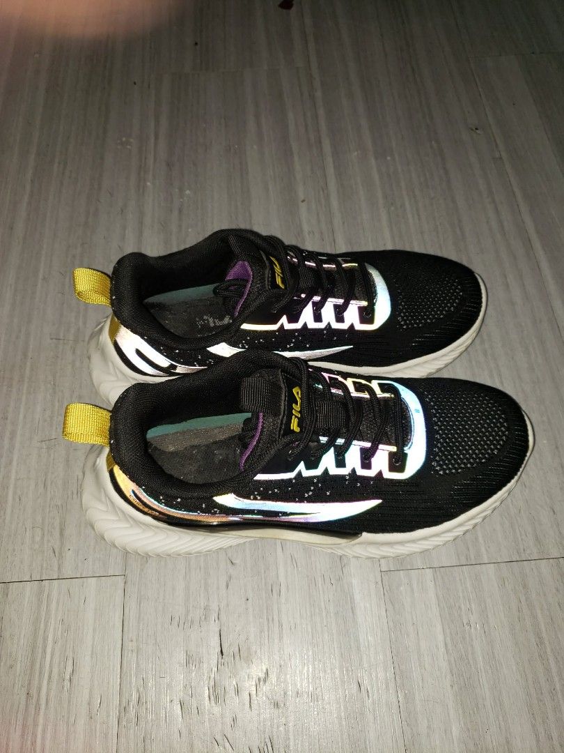 Fila Black Sneakers (Category: Sneakers) located in Quezon City. Submitted by vynnn26 (Listing ID 1460060795, Image 2). Description: - Black Fila sneakers - Size: 37 EUR - Rainbow reflective details - Yellow pull tabs at the heel - Suitable for running or casual wear - Minor signs of wear inside the shoe.