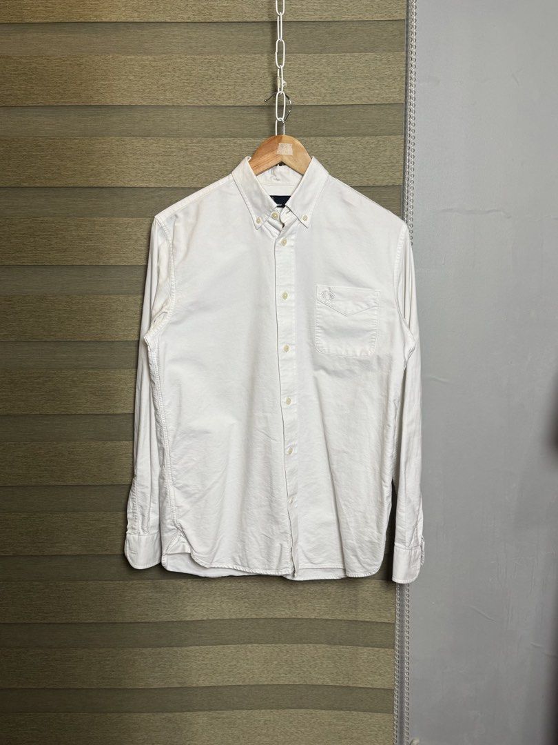 Fred Perry White Button-Down Shirt Size S (Category: Formal Shirts) located in Santa Ana. Submitted by thrift.sanctuary (Listing ID 1460082366, Image 1). Description: - Classic white button-down shirt - Brand: Fred Perry - Iconic embroidered laurel wreath logo on chest pocket - Button-down collar - Long sleeves with button cuffs - Versatile for casual and smart-casual outfits.