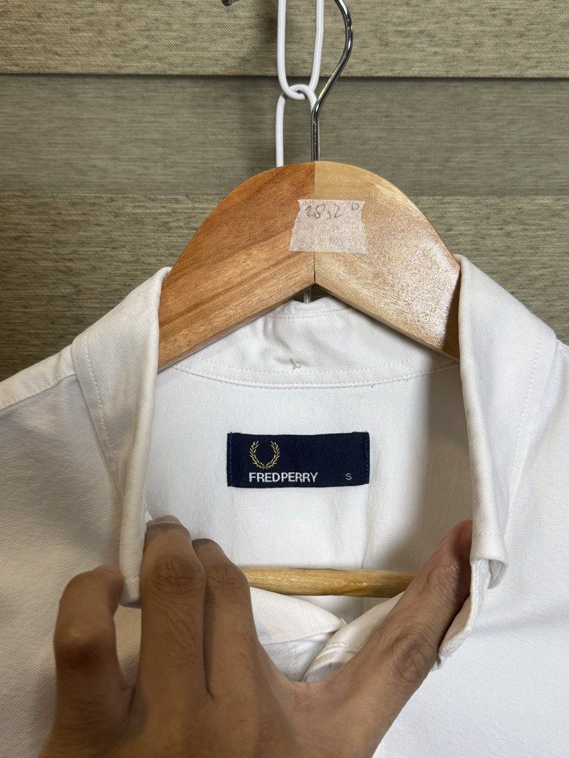 Fred Perry White Button-Down Shirt Size S (Category: Formal Shirts) located in Santa Ana. Submitted by thrift.sanctuary (Listing ID 1460082366, Image 3). Description: - Classic white button-down shirt - Brand: Fred Perry - Iconic embroidered laurel wreath logo on chest pocket - Button-down collar - Long sleeves with button cuffs - Versatile for casual and smart-casual outfits.