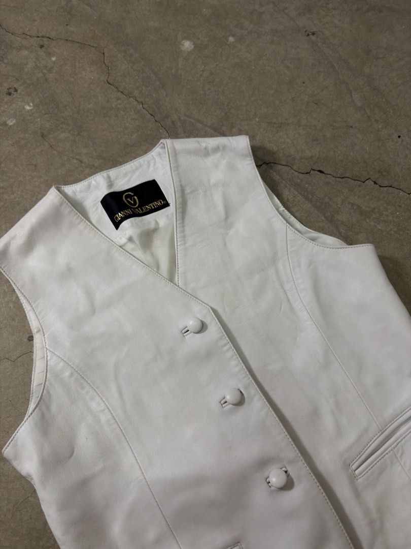 Gianni Valentino White Leather Vest (Category: Others Tops) located in Alfonso. Submitted by jbcamet (Listing ID 1460078196, Image 3). Description: - Genuine Gianni Valentino white leather vest - Classic button front closure - Two functional front pockets - Adjustable buckle at the back for a customized fit - Smooth lined interior - Ideal layering piece for any outfit.