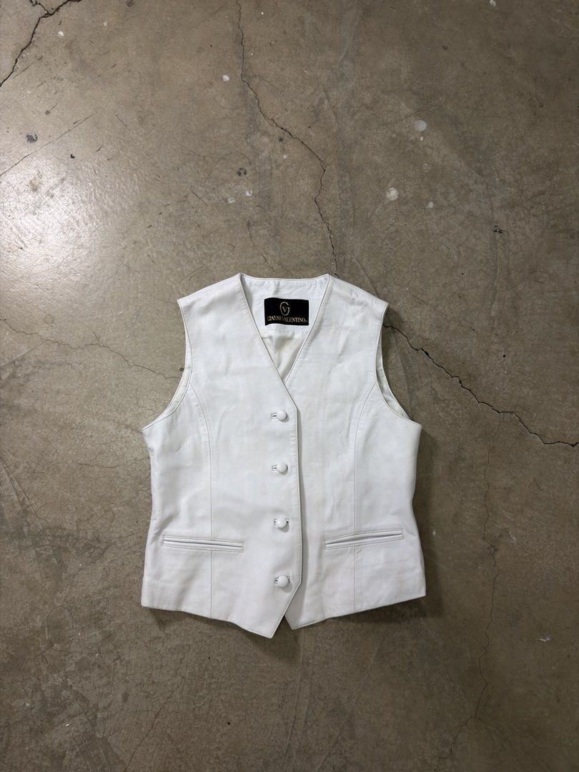 Gianni Valentino White Leather Vest (Category: Others Tops) located in Alfonso. Submitted by jbcamet (Listing ID 1460078196, Image 1). Description: - Genuine Gianni Valentino white leather vest - Classic button front closure - Two functional front pockets - Adjustable buckle at the back for a customized fit - Smooth lined interior - Ideal layering piece for any outfit.