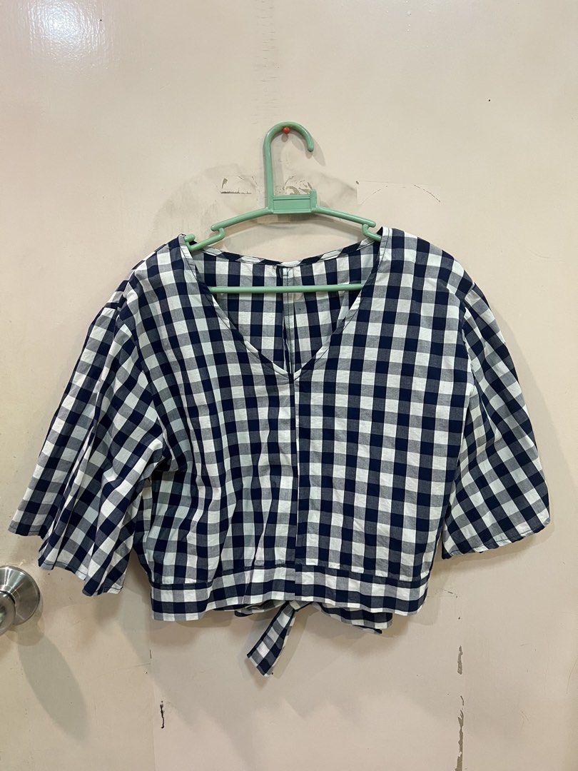 Gingham Checkered Cropped Top with Tie Back (Category: Blouses) located in Quezon City. Submitted by closetofk (Listing ID 1460003728, Image 1). Description: - Navy and white checkered cropped top - V-neckline with back tie detail - Short, fluttery sleeves - Versatile: pairs well with high-waisted jeans or skirts - Comfortable and stylish for casual wear.