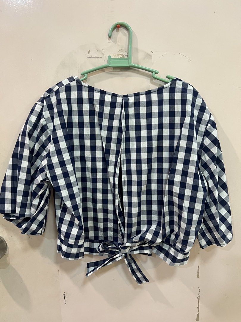 Gingham Checkered Cropped Top with Tie Back (Category: Blouses) located in Quezon City. Submitted by closetofk (Listing ID 1460003728, Image 2). Description: - Navy and white checkered cropped top - V-neckline with back tie detail - Short, fluttery sleeves - Versatile: pairs well with high-waisted jeans or skirts - Comfortable and stylish for casual wear.