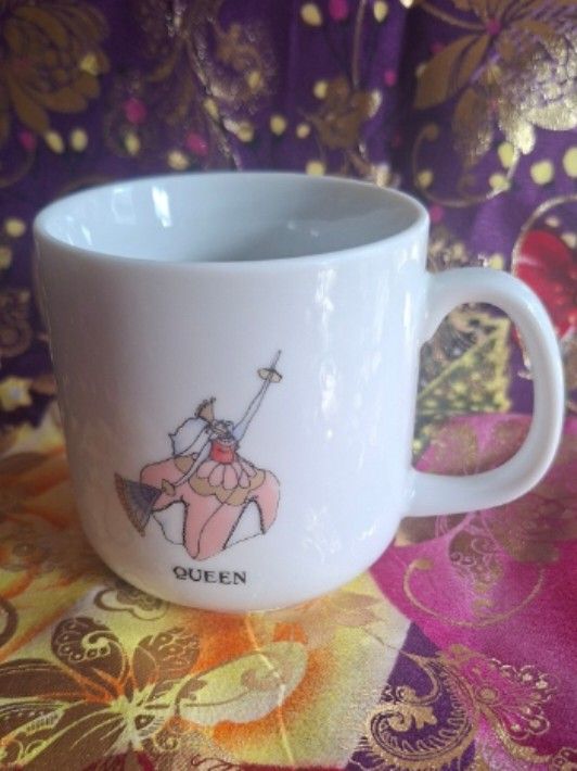 Glinda the Good Witch Mug (Category: Coffee & Tea Tableware) located in Consolacion. Submitted by luxekerei (Listing ID 1457263766, Image 1). Description: - white ceramic mug features a whimsical illustration of Glinda the Good Witch from The Wizard of Oz with the word "QUEEN" printed below.