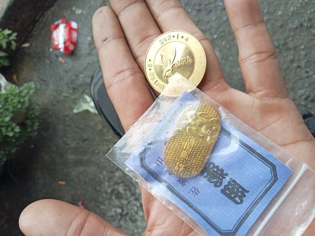 Gold Coins - Buddha and Nara Deer (Category: Currency) located in Caloocan City. Submitted by arielrosario22 (Listing ID 1459976452, Image 2). Description: - Two gold coins for sale. - Coin 1: Features a Buddha image, sealed in original blue packet. - Coin 2: Features a Nara deer design with text 'S62-1-4 NARA YASUHIRO'..