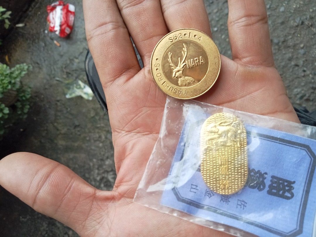 Gold Coins - Buddha and Nara Deer (Category: Currency) located in Caloocan City. Submitted by arielrosario22 (Listing ID 1459976452, Image 3). Description: - Two gold coins for sale. - Coin 1: Features a Buddha image, sealed in original blue packet. - Coin 2: Features a Nara deer design with text 'S62-1-4 NARA YASUHIRO'..