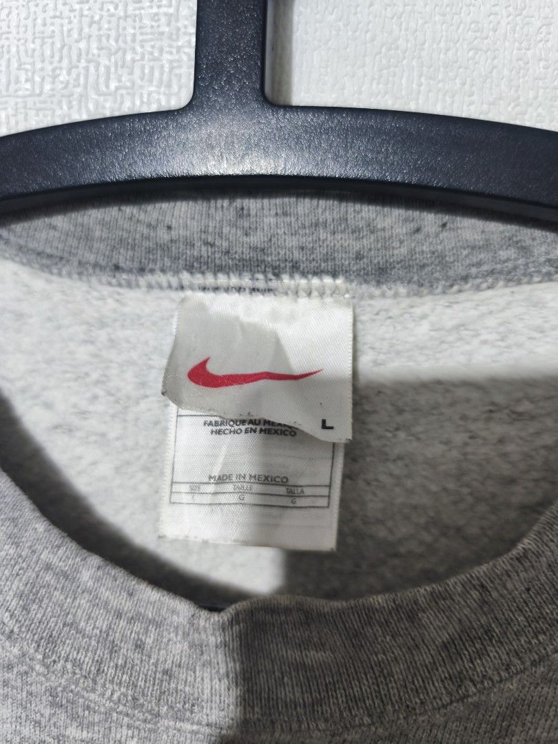 Grey Nike Crewneck Sweatshirt (Category: Coats, Jackets and Outerwear) located in Pasay City. Submitted by tananoy0508061 (Listing ID 1460076863, Image 2). Description: - Grey Nike crewneck sweatshirt - Size: L - Small embroidered Nike swoosh on chest - Label with 'L-24.5 x 27.5' included - Minor faint yellow stains on the front - Made in Mexico.