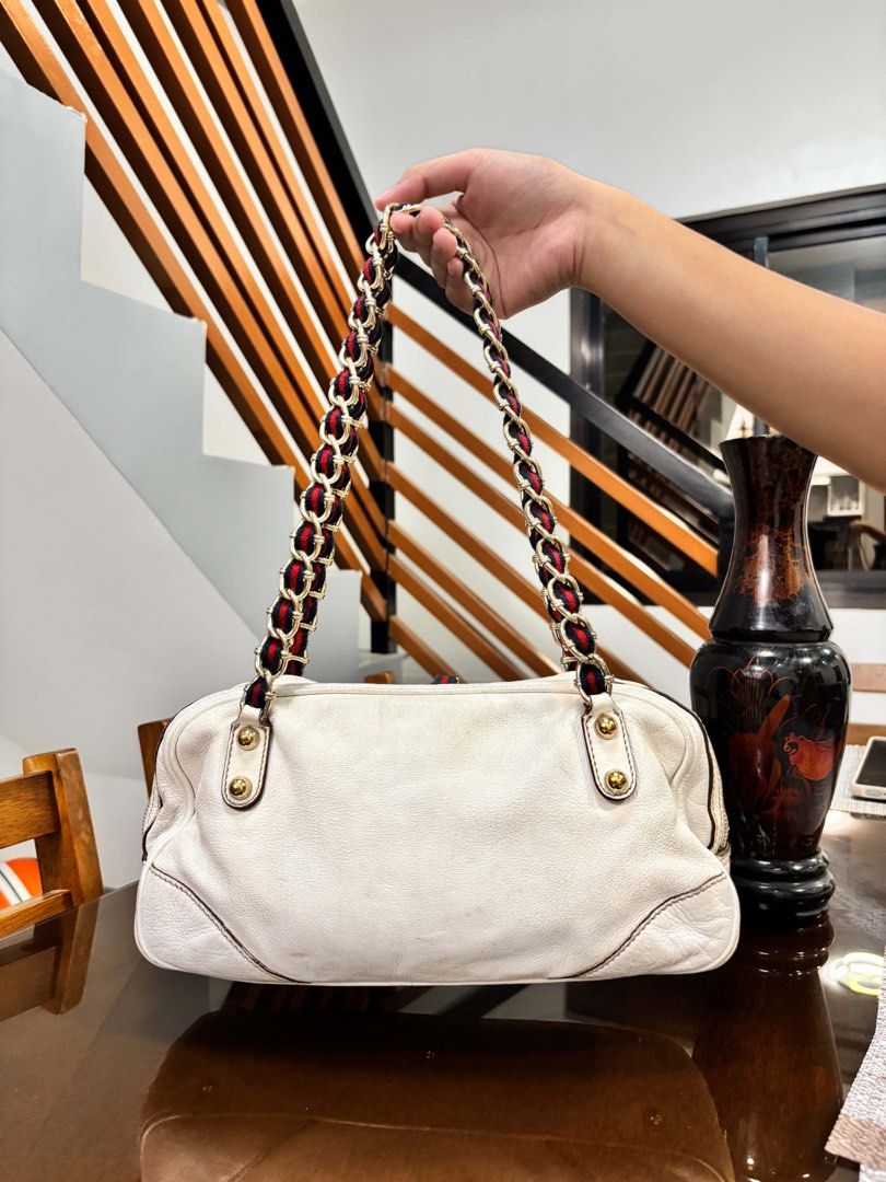 Gucci White Leather Shoulder Bag with Chain Strap (Category: Shoulder Bags) located in Manila. Submitted by nicolleteb90795 (Listing ID 1460046992, Image 2). Description: - White leather shoulder bag - Gold hardware and chain strap with red and blue accents - Two front zipper pockets - Zipper closure on top - Gold stud details on the bottom - Shows some signs of wear on leather and hardware.