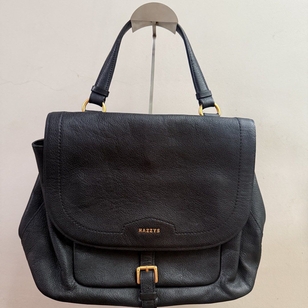 HAZZYS Black Leather Top Handle Bag (Category: Luxury Bags & Wallets) located in Cainta. Submitted by shangitta (Listing ID 1459953651, Image 3). Description: Selling this for a very low price because I’m declutterring :) Very classy and easy to pair with anything! • Black pebbled leather • Gold-tone HAZZYS hardware • Spacious interior with multiple compartments • Main zippered compartment for added security • Front buckle detail • Back pocket • 
