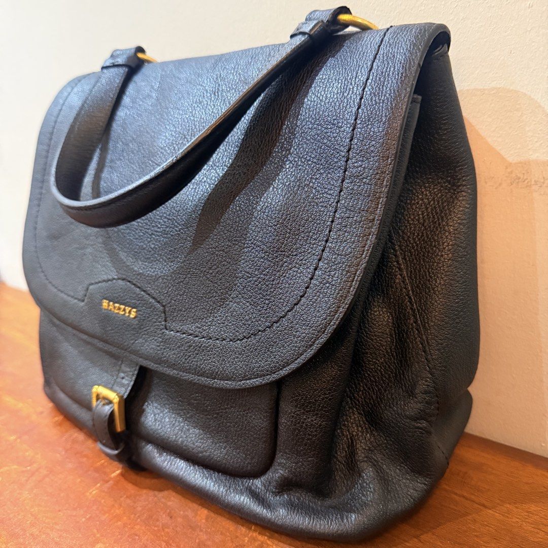 HAZZYS Black Leather Top Handle Bag (Category: Luxury Bags & Wallets) located in Cainta. Submitted by shangitta (Listing ID 1459953651, Image 2). Description: Selling this for a very low price because I’m declutterring :) Very classy and easy to pair with anything! • Black pebbled leather • Gold-tone HAZZYS hardware • Spacious interior with multiple compartments • Main zippered compartment for added security • Front buckle detail • Back pocket • 