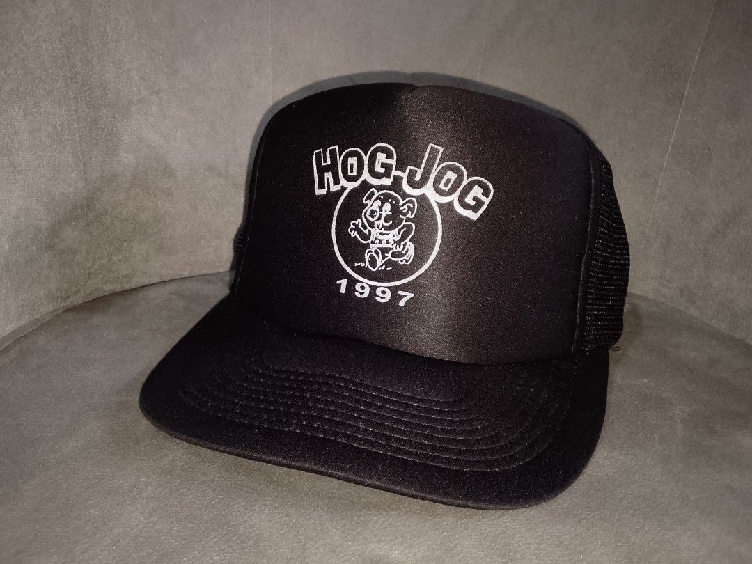 Vintage Hog Jog 1997 Trucker Hat (Category: Caps & Hats) located in Binangonan. Submitted by yuristalin888 (Listing ID 1459914694, Image 2). Description: This vintage black trucker hat features a structured front panel screen-printed with a white "HOG-JOG" graphic, a running cartoon animal mascot inside a circle, and the year "1997" below. It is styled with a slight curved brim and breathable mesh back panels..