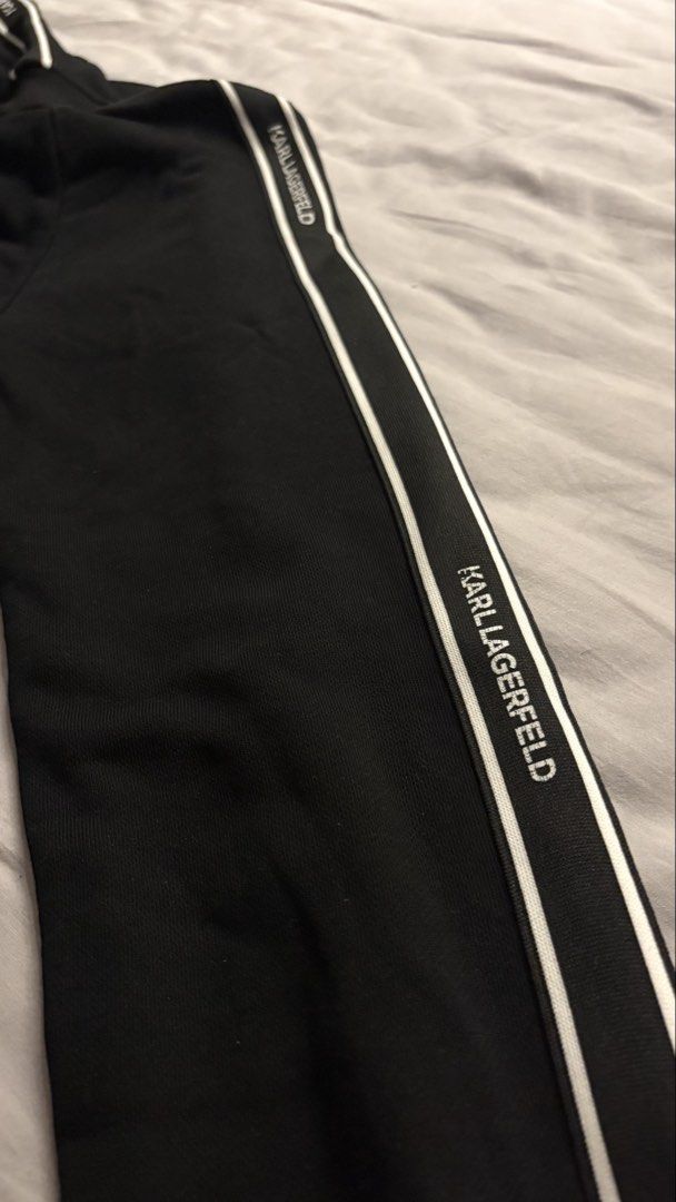 Karl Lagerfeld Black Track Jacket with Logo (Category: Coats, Jackets and Outerwear) located in Dasmarinas. Submitted by stephen08e (Listing ID 1460026297, Image 3). Description: - Authentic Karl Lagerfeld black track jacket - Features iconic Karl Lagerfeld character logo on chest - White stripe detailing with repeating brand name on sleeves - Full zip front closure - Convenient side pockets.