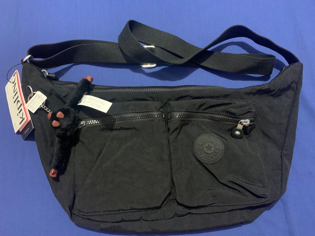 Kipling Black Nylon Sling Bag with Monkey Keychain (Category: Cross-body Bags) located in Malabon City. Submitted by eeroc (Listing ID 1460103714, Image 1). Description: - Authentic Kipling sling bag - Durable nylon material - Features a front zip pocket and an additional smaller zip pocket - Includes the iconic Kipling monkey charm - Adjustable strap for personalized comfort - Ideal for everyday wear and travel.