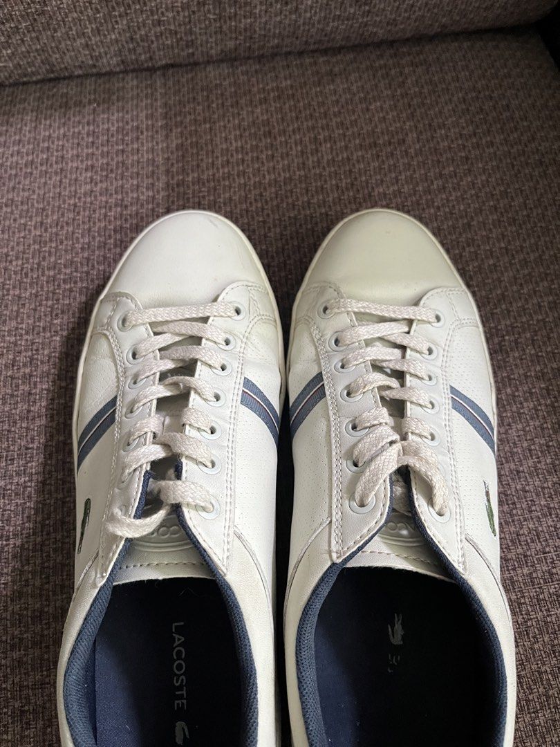 Lacoste White Leather Sneakers with Blue Stripes (Category: Casual Shoes) located in Manila. Submitted by lowkeyxan (Listing ID 1459986136, Image 2). Description: Original White leather Lacoste sneakers. Features the iconic crocodile logo on the side. Has a navy blue inner lining and subtle blue stripes on the side. Laces are white. Good for casual wear..