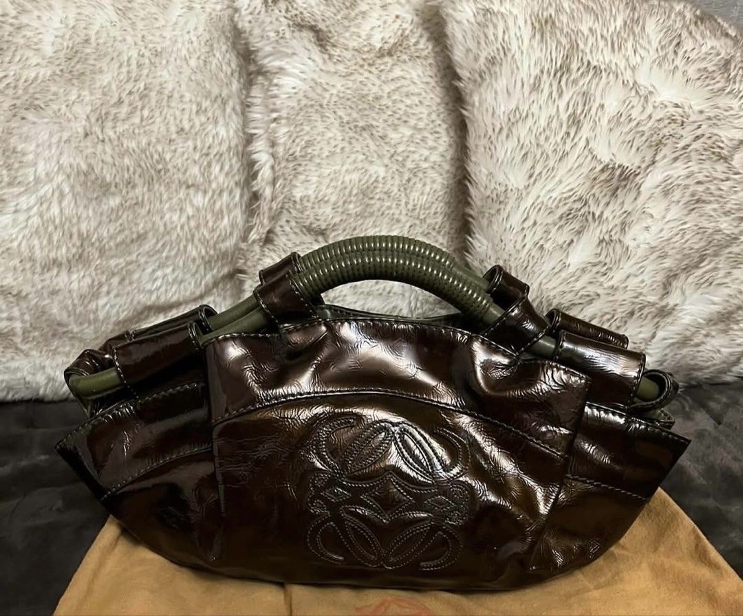 Loewe Patent Leather Handbag (Category: Luxury Bags & Wallets) located in Manila. Submitted by chantalsalonga (Listing ID 1460089788, Image 1). Description: - Authentic Loewe brown patent leather handbag - Features iconic embossed Anagram logo on the front - Unique and stylish green handle detail - Comes with original Loewe dust bag - A versatile and fashionable accessory.