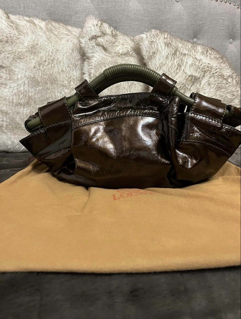 Loewe Patent Leather Handbag (Category: Luxury Bags & Wallets) located in Manila. Submitted by chantalsalonga (Listing ID 1460089788, Image 2). Description: - Authentic Loewe brown patent leather handbag - Features iconic embossed Anagram logo on the front - Unique and stylish green handle detail - Comes with original Loewe dust bag - A versatile and fashionable accessory.